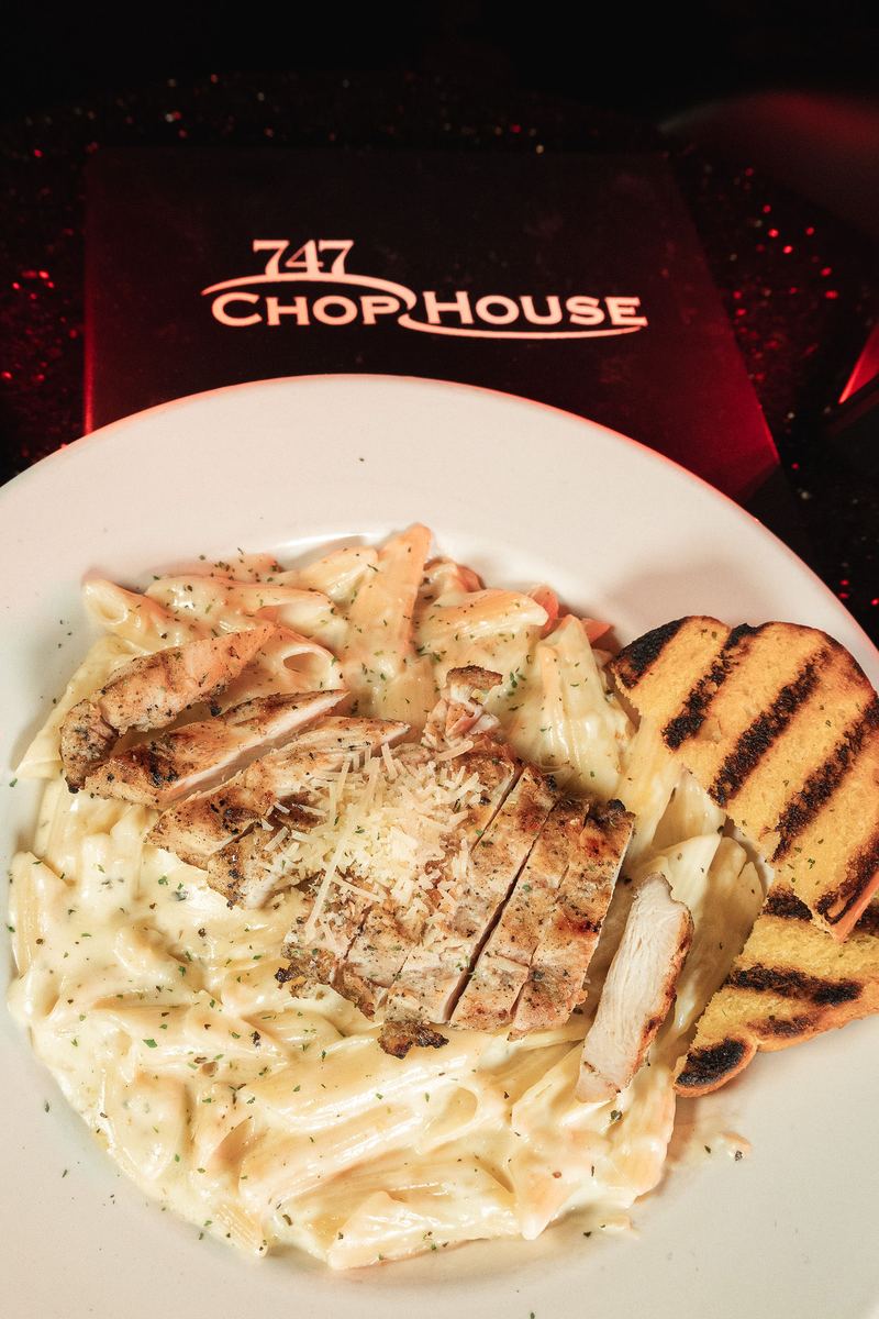 Chicken alfredo pasta with garlic bread from 747 Chop House at Capital Cabaret