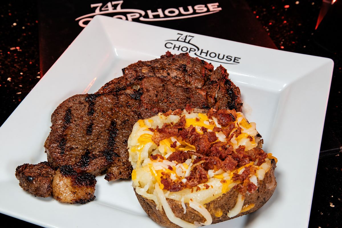 Ribeye steak and loaded baked potato from 747 Chop House at Capital Cabaret
