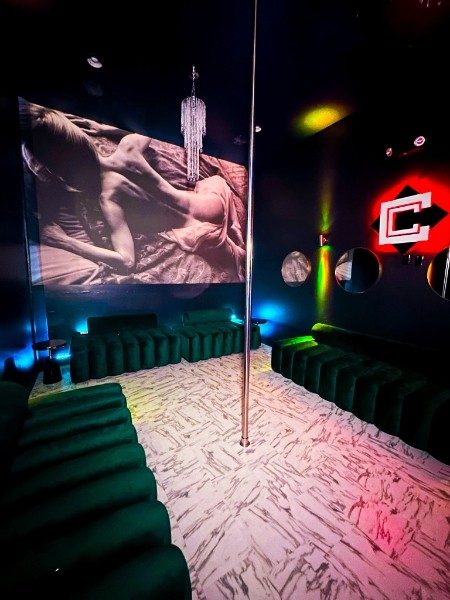 Inside a private VIP suite at Capital Cabaret, with green velvet seating and a private stage